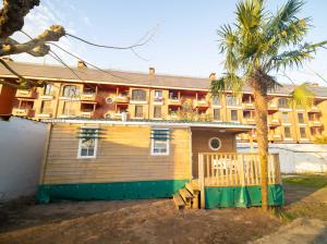 a small house with a palm tree in front of a building at Alojamiento - Bungalows en el centro de Laredo a 200 m de la playa in Laredo