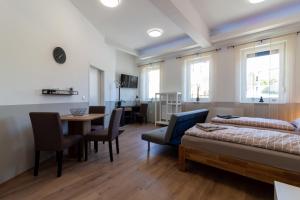 a living room with a bed and a table and chairs at Apartment 4you in Oberpullendorf