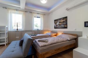 1 dormitorio con 2 camas y sofá en Apartment 4you, en Oberpullendorf