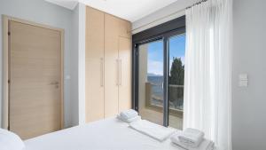 a bedroom with a large window and a bed with two towels at Agni Suites in Nikiana