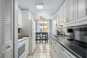 a kitchen with white cabinets and a black counter top at Only 5 minutes to Rogers with Downtown Views in Edmonton