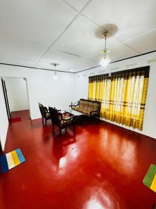 Prestiva Stay في أنورادابورا: غرفة معيشة مع أرضية حمراء وأريكة