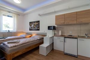 two beds in a room with a kitchen at Apartment 4you in Oberpullendorf