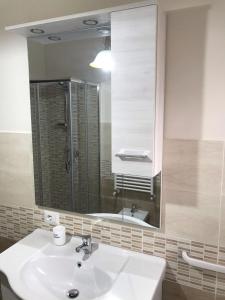 Residenza delle Rose في لاميزيا تيرمي: حمام مع حوض ومرآة كبيرة