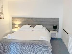 sypialnia z dużym białym łóżkiem z dwoma stołami w obiekcie Bed & Bike Zagreb studio apartment w Zagrzebiu