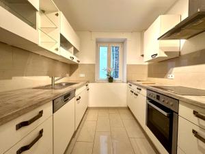 uma cozinha com armários brancos, um lavatório e uma janela em Ferienwohnungen-Traben-Trarbach em Traben-Trarbach