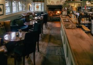 ヘブデン・ブリッジにあるWhite Lionのテーブルと椅子、暖炉のあるレストラン