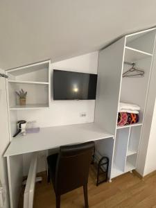 a white desk with a tv on a wall at Apartments & Rooms L E F T RIVER Belgrade in Belgrade