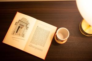 un libro abierto con una taza de café sobre una mesa en Dylan Hotel NYC, en Nueva York