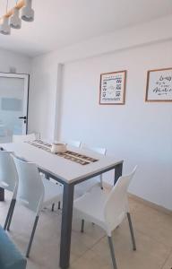 a dining room with a table and white chairs at Departamento Super céntrico in Puerto Madryn