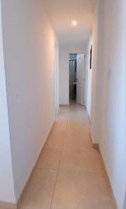 a hallway with white walls and a tile floor at Departamento Super céntrico in Puerto Madryn