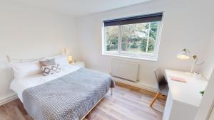 1 dormitorio con cama, ventana y escritorio en Inviting Apt near the Valley Park en Exeter