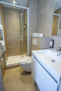 a bathroom with a shower and a toilet and a sink at Hotel Chalet De L'isere in Cannes