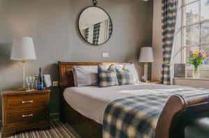 um quarto com uma cama e um espelho na parede em White Lion em Hebden Bridge