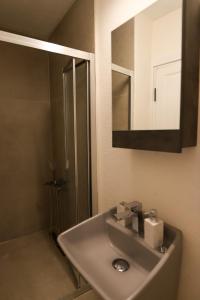 a bathroom sink with a shower and a mirror at Lilla Maria Guesthouse in Ayvalık