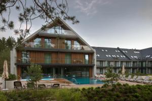 ein großes Gebäude mit einem Pool und einem Resort in der Unterkunft Hotel Saltic Resort & Spa Łeba in Łeba