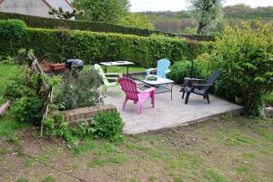 een patio met stoelen en een tafel in de tuin bij Le Clair Matin 