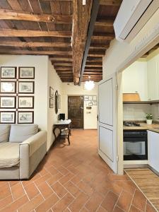 Il comprend un salon avec un canapé et une cuisine. dans l'établissement Lucca Walls Dream - Air Cond - Wi-Fi - Panoramic in front of the historical Walls -, à Lucques