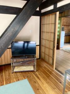 een woonkamer met een flatscreen-tv op zolder bij 田舎の別荘 かすみ草 in Shōgahora