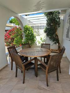 a wooden table and chairs on a patio at Pretty villa with private pool in Los Alcázares