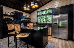 a kitchen with a bar and a refrigerator at Enchanting Escape for Two in Broken Bow