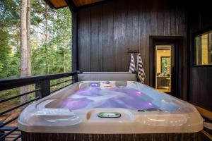 a jacuzzi tub sitting on the deck of a cabin at Enchanting Escape for Two in Broken Bow