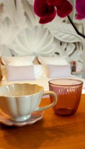 una taza y un tazón en una mesa con flores en "Chez Lyly et Juju" Piscine&Calme 3Chambres, en Angers
