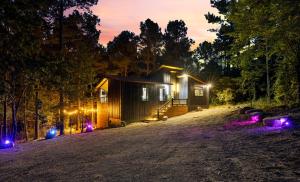 a cabin in the woods at night with lights at Enchanting Escape for Two in Broken Bow
