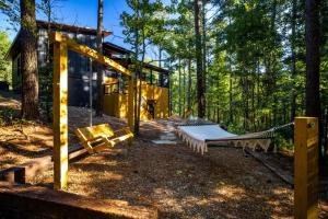 a house with a hammock in the woods at Enchanting Escape for Two in Broken Bow