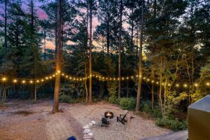 a string of lights over a fire in the woods at Enchanting Escape for Two in Broken Bow