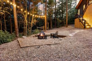 a firepit with a bench and a string of lights at Enchanting Escape for Two in Broken Bow