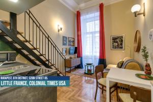 a living room with a staircase with red curtains at Little Americas Colonial Times Apts in Budapest