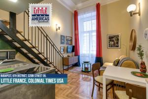 a living room with a staircase with red curtains at Little Americas Colonial Times Apts in Budapest