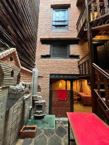 a room with a brick building with a red table at NEWA:INN in Kathmandu