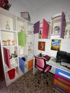 an office with a desk and a chair and shelves at Alojamiento Ruizo in Lorca