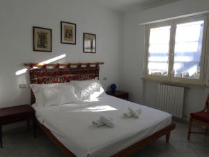 a bedroom with a bed with two towels on it at Homiday - Villino Caroli in Pineto
