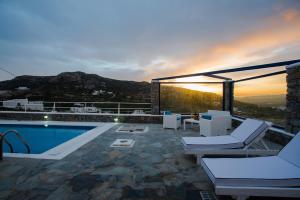 un patio con piscina, sillas y puesta de sol en Mykonos Pro-care Suites, en Ano Mera