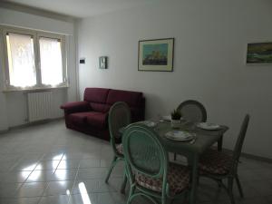 a living room with a table and a red couch at Homiday - Villino Caroli in Pineto