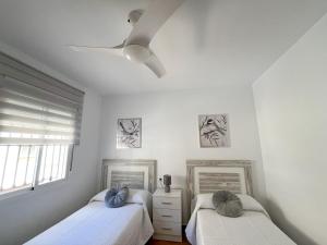 1 Schlafzimmer mit 2 Betten und einem Deckenventilator in der Unterkunft Casa Rural La Escapadita in Benaoján