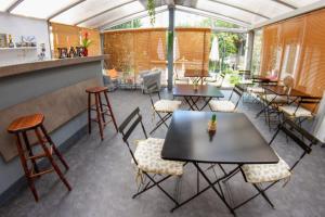 a restaurant with tables and chairs and a bar at Hotel Chalet De L'isere in Cannes