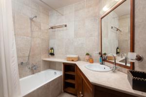 a bathroom with a tub and a sink and a shower at Kalimera Archanes Village in Archanes