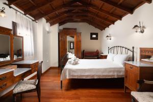 a bedroom with a white bed and a wooden ceiling at Kalimera Archanes Village in Archanes