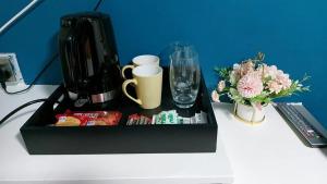 una bandeja negra en una mesa blanca con tazas y bebidas en Avalon Hotel en Brighton & Hove