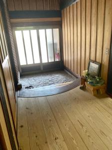 une chambre vide avec un lit dans une chambre avec une fenêtre dans l'établissement 田舎の別荘 かすみ草, à Shōgahora