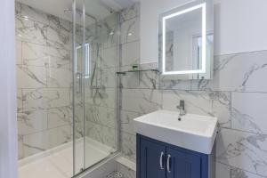 a bathroom with a sink and a shower at Swan Revived Hotel in Milton Keynes
