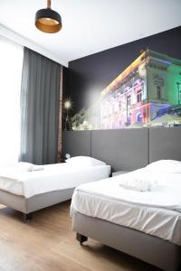 une chambre avec deux lits et un bâtiment avec des lumières dans l'établissement ADLER Bed&Breakfast, à Łódź