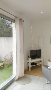 un salon avec une télévision et une chaise dans l'établissement Chambre d'amour, à Villeneuve-lès-Avignon
