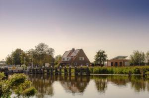 una casa sentada junto a un cuerpo de agua en Aan de Amstel, en De Kwakel