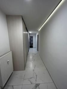 a hallway with white walls and a white tile floor at Renewed 2 Bedroom Apartment with Parking in Ljubljana
