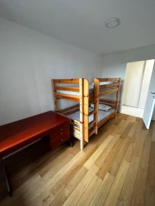 a room with a bed and a desk and a wooden floor at Renewed 2 Bedroom Apartment with Parking in Ljubljana